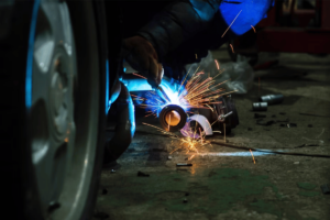 A person performing metal fabrication on a steel tube in El Paso.