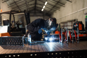 A welder in a mask performing custom metal fabrication.