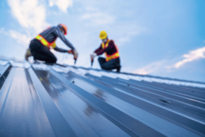 Two people installing a metal roof in El Paso.