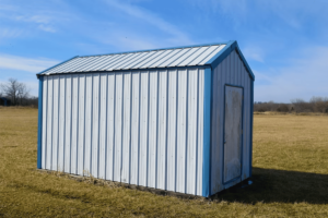 A white and blue metal shed in a field in El Paso.