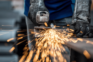 A person using a tool to perform sheet metal fabrication in El Paso.